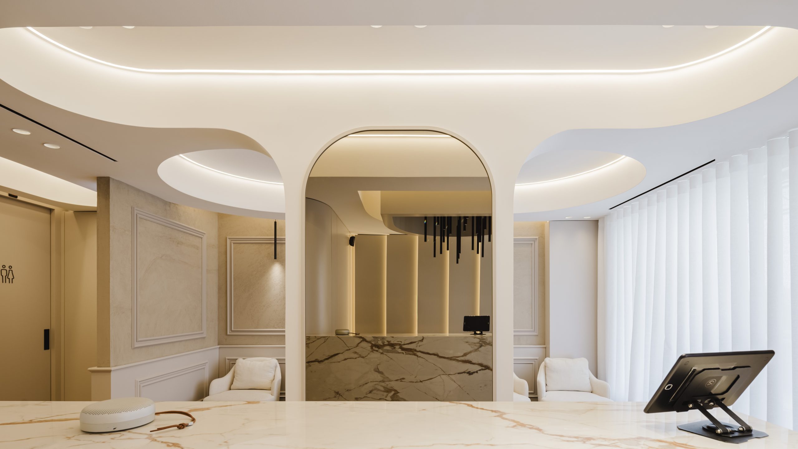 Receção da clínica dentária YourDental em Almada com balcão curvo e detalhe em mármore – Projeto Radian 2025