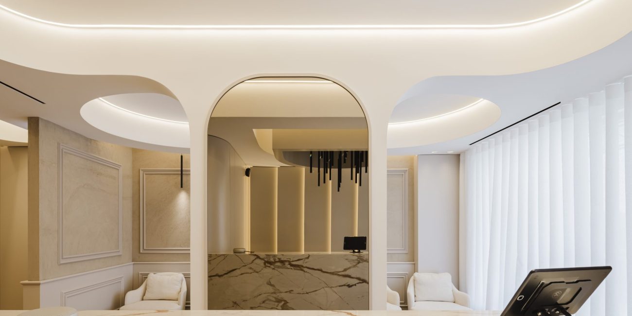 Receção da clínica dentária YourDental em Almada com balcão curvo e detalhe em mármore – Projeto Radian 2025