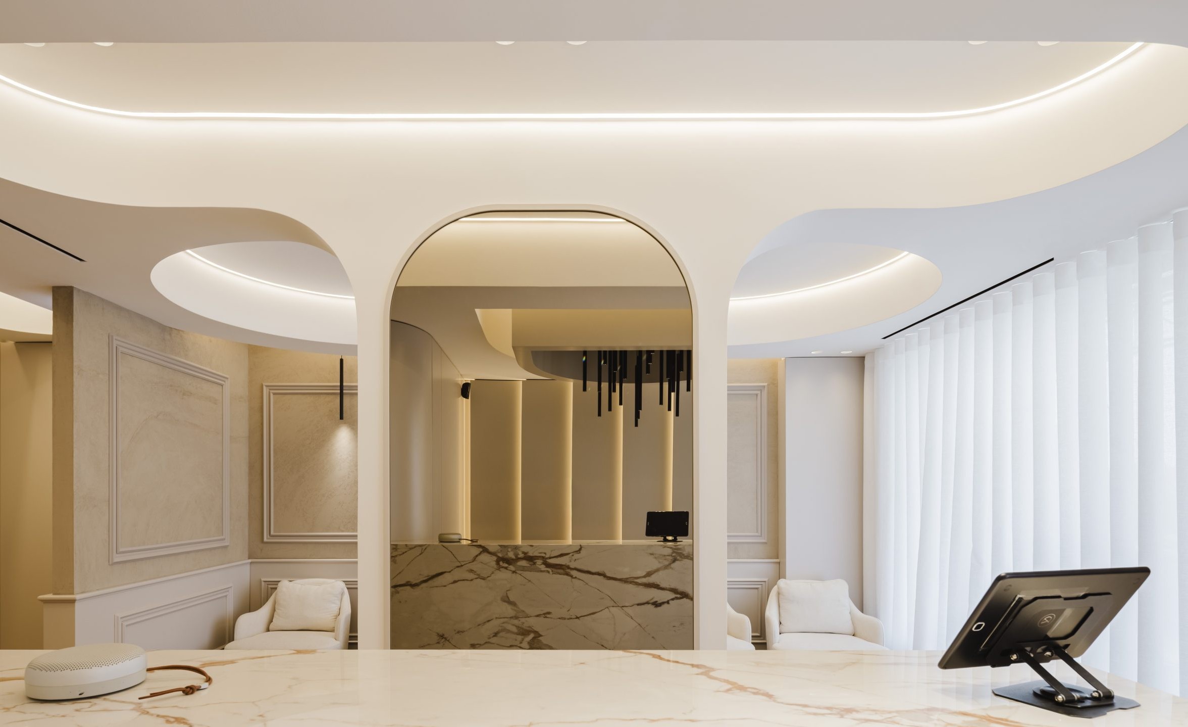 Receção da clínica dentária YourDental em Almada com balcão curvo e detalhe em mármore – Projeto Radian 2025